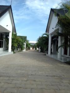 an empty courtyard of a building with a bridge in the background at Wasini gardens,, vingazini in Mtwapa