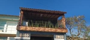 a building with a balcony with plants in it at Hospedagem Dorna Casa 6A Itaguaí in Itaguaí
