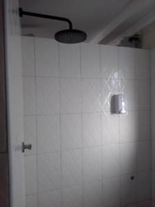 a white tiled shower with a light on the wall at Wasini gardens,, vingazini in Mtwapa
