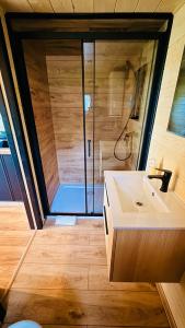 a bathroom with a shower and a white sink at Mazurski Widok 2 in SzczybaÅ‚y OrÅ‚owskie