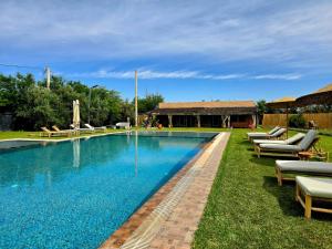 a large swimming pool with lounge chairs next to it at Admylla in Sraghna