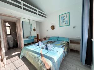 a bedroom with a large bed and a bathroom at Fuerte premium blue in Costa Calma