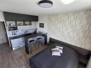 a small room with a bed and a kitchen at Sunset Studio Apartment in Poprad +17 photos