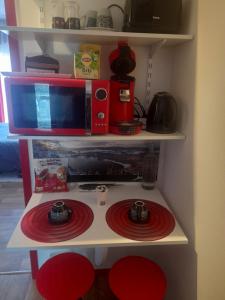 a microwave on a shelf with red plates on it at Chambre chez Danuta in Champagnole