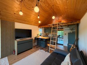 a living room with a couch and a kitchen with a loft at Dushka Mountain Cabin in Belec