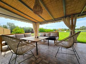 a patio with a couch and a table and chairs at Admylla in Sraghna