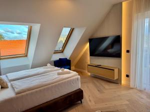 a bedroom with a bed and a flat screen tv at Luxury Rooftop Apartment LEGRAND in Vienna