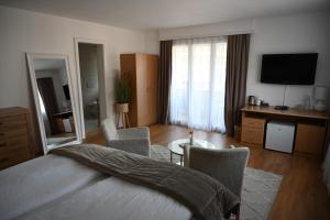 a bedroom with a bed and a living room with a television at Hotel Europe Brig in Brig
