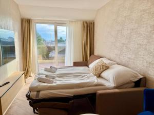 a bed in a room with a large window at Luxury Rooftop Apartment LEGRAND in Vienna