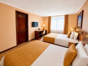 a hotel room with two beds and a television at Hotel Endamo in Latacunga +9 photos