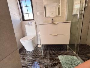 a bathroom with a toilet and a shower at Fuerte premium blue in Costa Calma