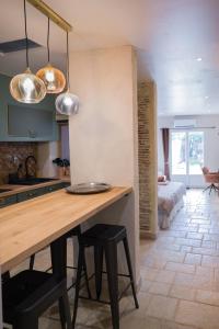 a kitchen with a wooden table and some lights at Le Repaire d'Argenson in Bergerac