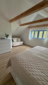 a white bedroom with a bed and a window at Pod Borovicí Broumy in Broumy