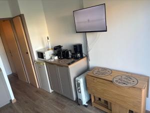a room with a tv on the wall and a table at 423 Résidence Aphrodite naturiste in Leucate-Plage
