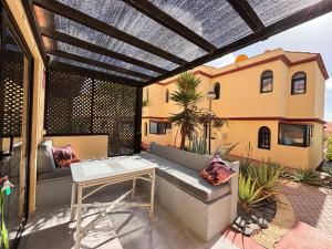 a patio with a bench and a table and a building at Fuerte premium blue in Costa Calma