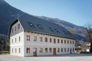 a large white building with a black roof at Vila Soča in Bovec