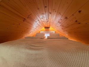 a large white bed in a wooden room at Dushka Mountain Cabin in Belec
