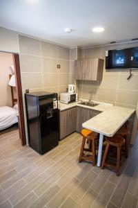 a kitchen with a black refrigerator and a table at Edificios Refugio in Nevados de Chillan +9 photos