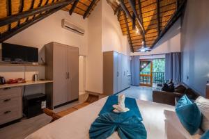 a bedroom with a large bed and a living room at Kruger Park Lodge - Modern Unit 225B in Hazyview