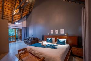 a bedroom with a large bed and a couch at Kruger Park Lodge - Modern Unit 225B in Hazyview +38 photos