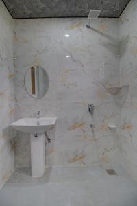 a white bathroom with a sink and a mirror at Royal Cliff Resort Pahalgam in Pahalgām +12 photos