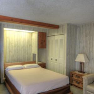 a bedroom with a bed and a lamp and a chair at Eden Roc Downtown in Ocean City