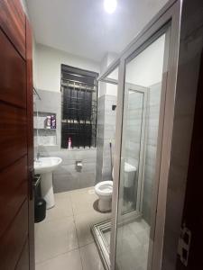 a bathroom with a toilet and a sink at Luxury Ntinda Apartment with Wi Fi and Netflix in Kampala +9 photos