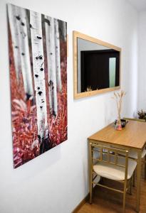 a painting of trees on a wall next to a table at Adori Boutique in Eforie Nord