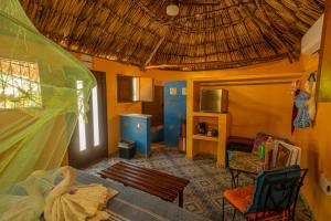 ein Wohnzimmer mit Sofa und Strohdach in der Unterkunft The Pickled Onion Hotel & Restaurant Uxmal in Santa Elena