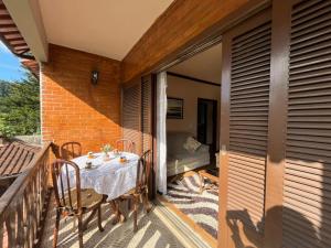 a patio with a table and chairs on a balcony at Casa aconchegante para família- 3,5 km do centro histórico in Petrópolis