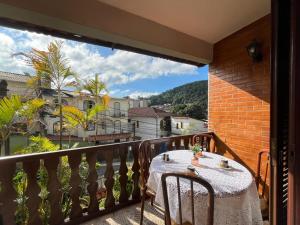 a table and chairs on a balcony with a view at Casa aconchegante para família- 3,5 km do centro histórico in Petrópolis