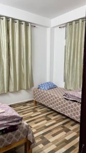 ein Zimmer mit zwei Betten und einem Fenster in der Unterkunft Backpackers nest in Dirang Dzong