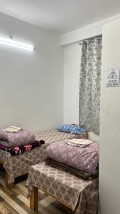 ein Zimmer mit zwei Betten, einem Tisch und einem Fenster in der Unterkunft Backpackers nest in Dirang Dzong