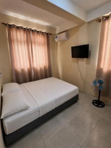 a bedroom with a bed and a flat screen tv at Barefoot Apartments in Roseau +49 photos