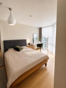a bedroom with a bed and a desk and a window at ToVa Apartamentai in Šventoji