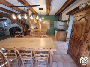 a kitchen with a large wooden table and chairs at Presbytère st michel de léon in Lacaze