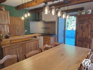 a kitchen with a large wooden table and chairs at Presbytère st michel de léon in Lacaze