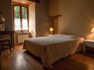 a bedroom with a bed and two tables and a window at Presbytère st michel de léon in Lacaze