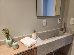 a bathroom with a sink and a mirror at Suítes Bela Vista in Pomerode +40 photos