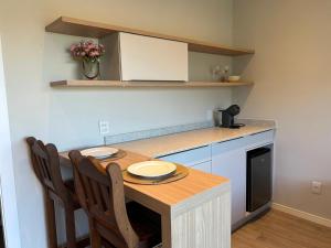 a kitchen with a table with two chairs and a counter at Suítes Bela Vista in Pomerode