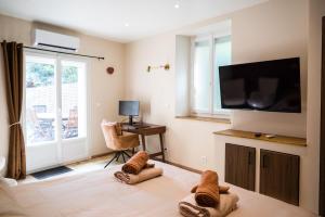a room with a bed with a flat screen tv at Le Repaire d'Argenson in Bergerac