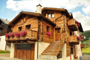 a wooden house with balconies and stairs on it at Armonia Livigno Appartamenti in Livigno
