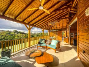 a porch with a wooden roof with chairs and a table at Bohème Chic, 2 Suites, Terrasse XXL in Le Gosier