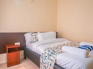 a small bedroom with a bed and a table at Easy Stay Rongai Poolside 2BR near Karen WiFi and Netflix in Ongata Rongai  +12 photos