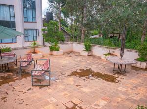 a patio with chairs and tables and a building at Easy Stay Rongai Poolside 2BR near Karen WiFi and Netflix in Ongata Rongai 