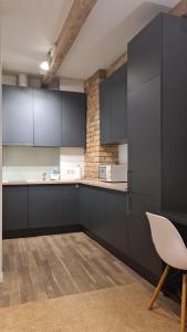 a kitchen with black cabinets and a white chair at Lovely 1-bedroom condo in Riga +9 photos