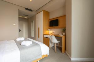 a hotel room with a bed and a desk at Hotel Bologna in Vlorë