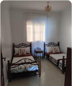 a bedroom with two beds and a window at Appartement vue mer à Fnideq in Fnidek