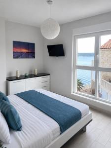 a white bedroom with a large bed and a window at Villa Jasmin Posedarje in Posedarje +55 photos