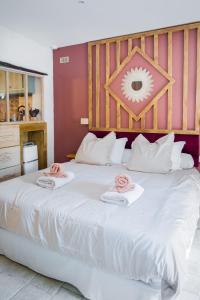 a large white bed with pink towels on top of it at Le Repaire d'Argenson in Bergerac